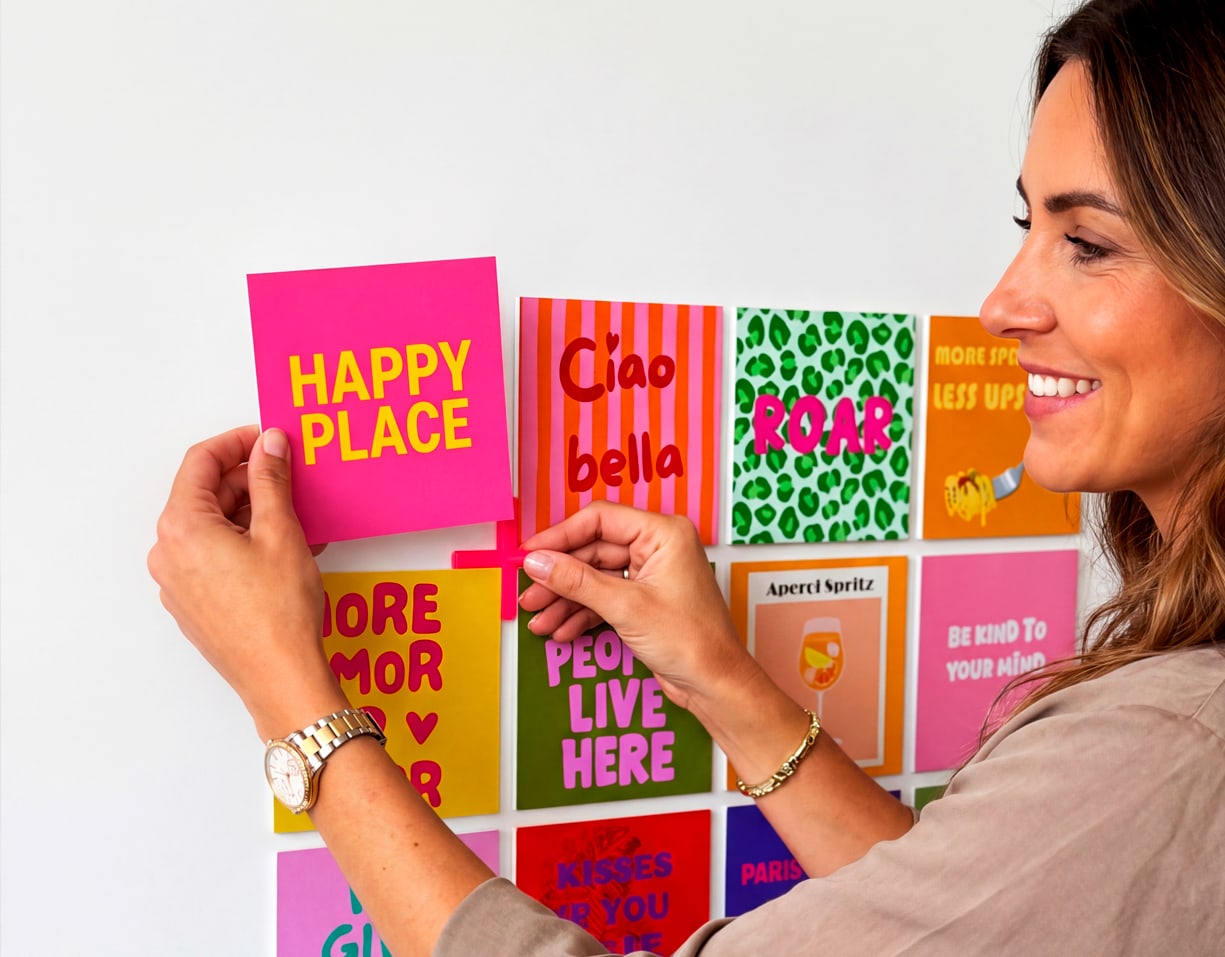 Een vrouw die een happy shape toevoegt aan haar muur naast andere happy shapes.